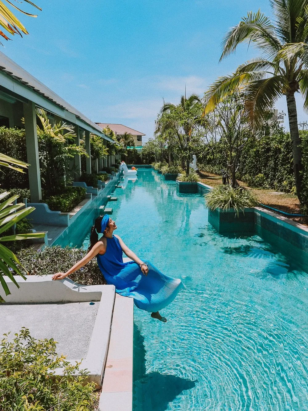 Girl sitting on the edge of swimming pool