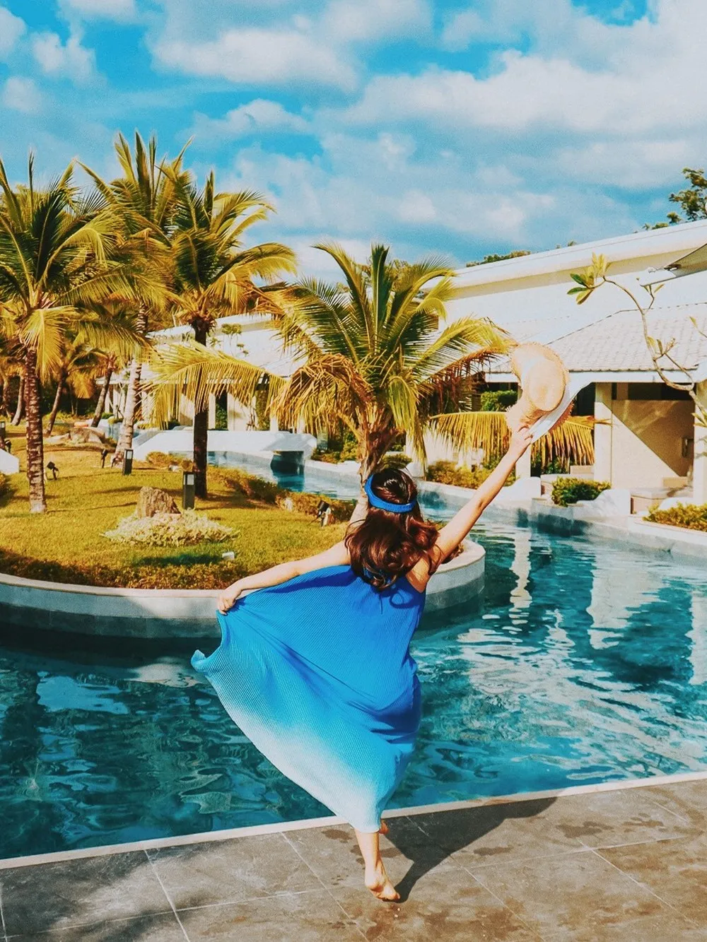 Girl dancing in front of swimming pool